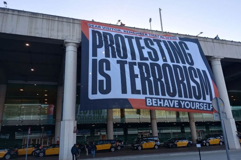 Una bandeiròla a l’aeropòrt de Barcelona avertís los toristas en lor disent qu’en Espanha protestar es considerat coma de terrorisme