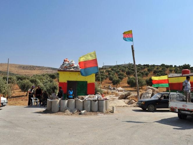 Drapèls del PYD sus un contraròtle de seguretat d'una vila curda al nord de Halap (Alep)